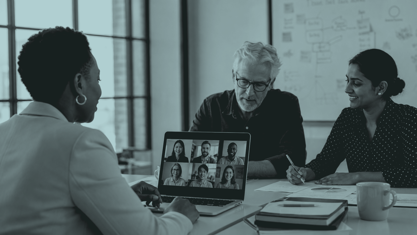 A hybrid team meeting with remote colleagues on screen