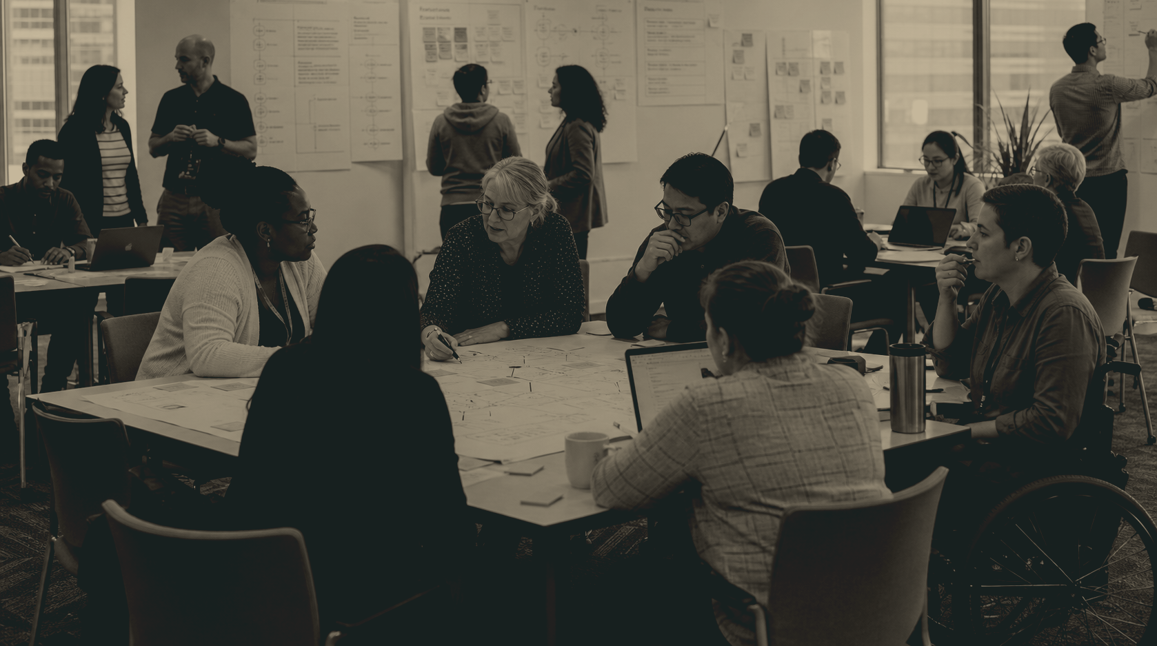 A large working session with teams mapping work across tables