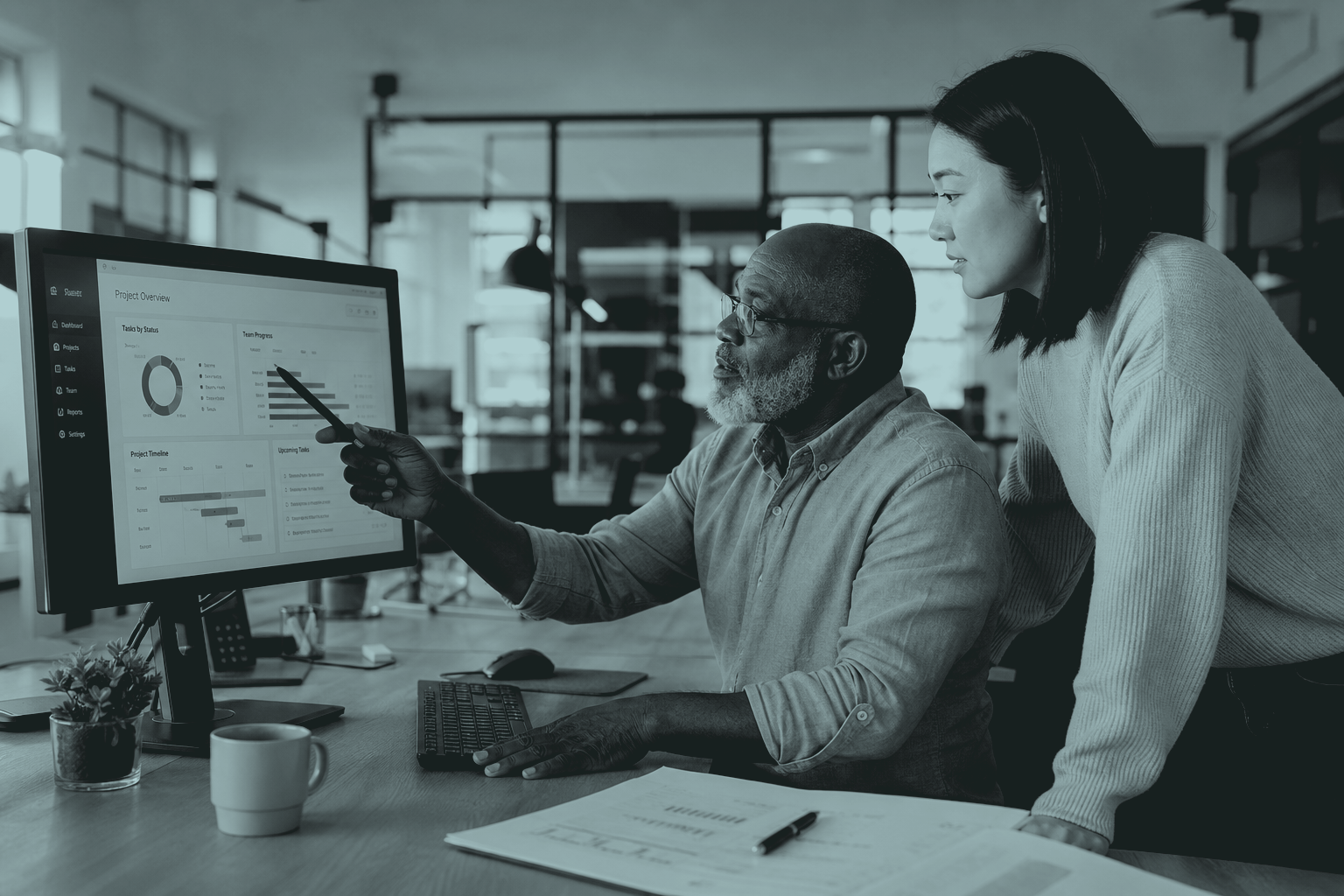 Two colleagues reviewing a project dashboard together
